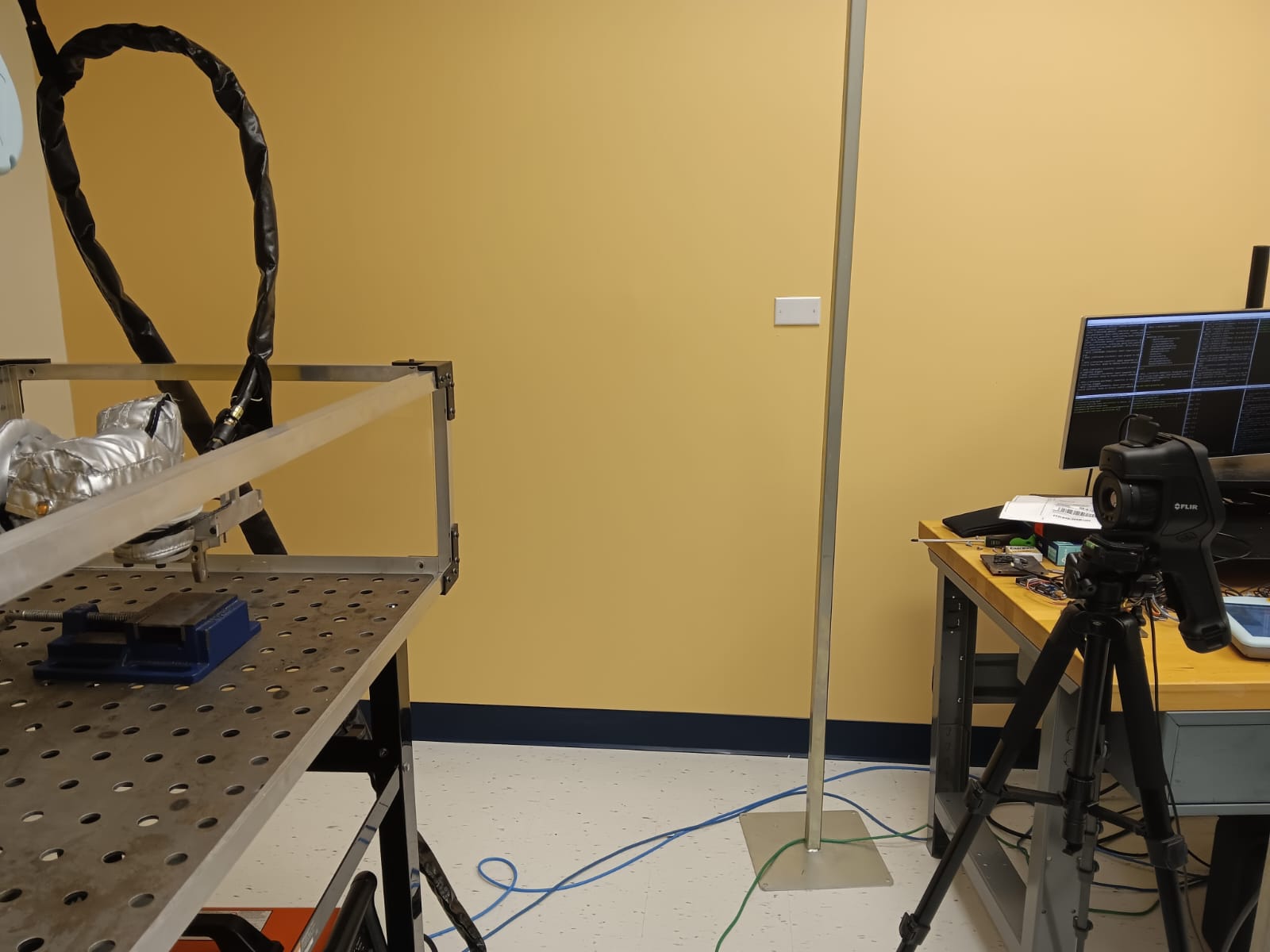 Physical manufacturing setup with a robot-mounted tool and a FLIR thermal camera.